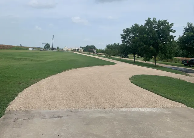 Chip seal driveway curving across a flat Texas property